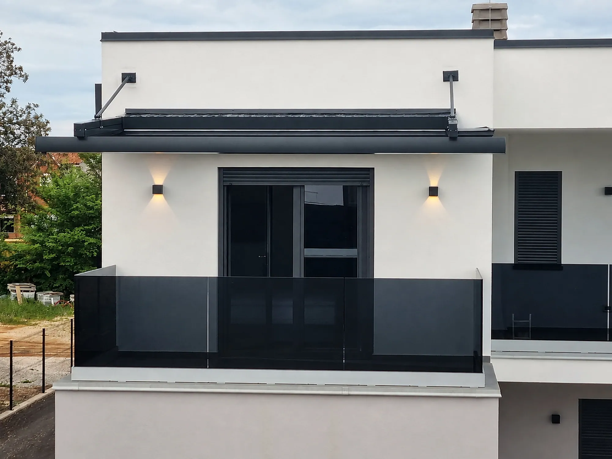 Balkon mit dunklem Glasgeländer an einem modernen Wohnhaus