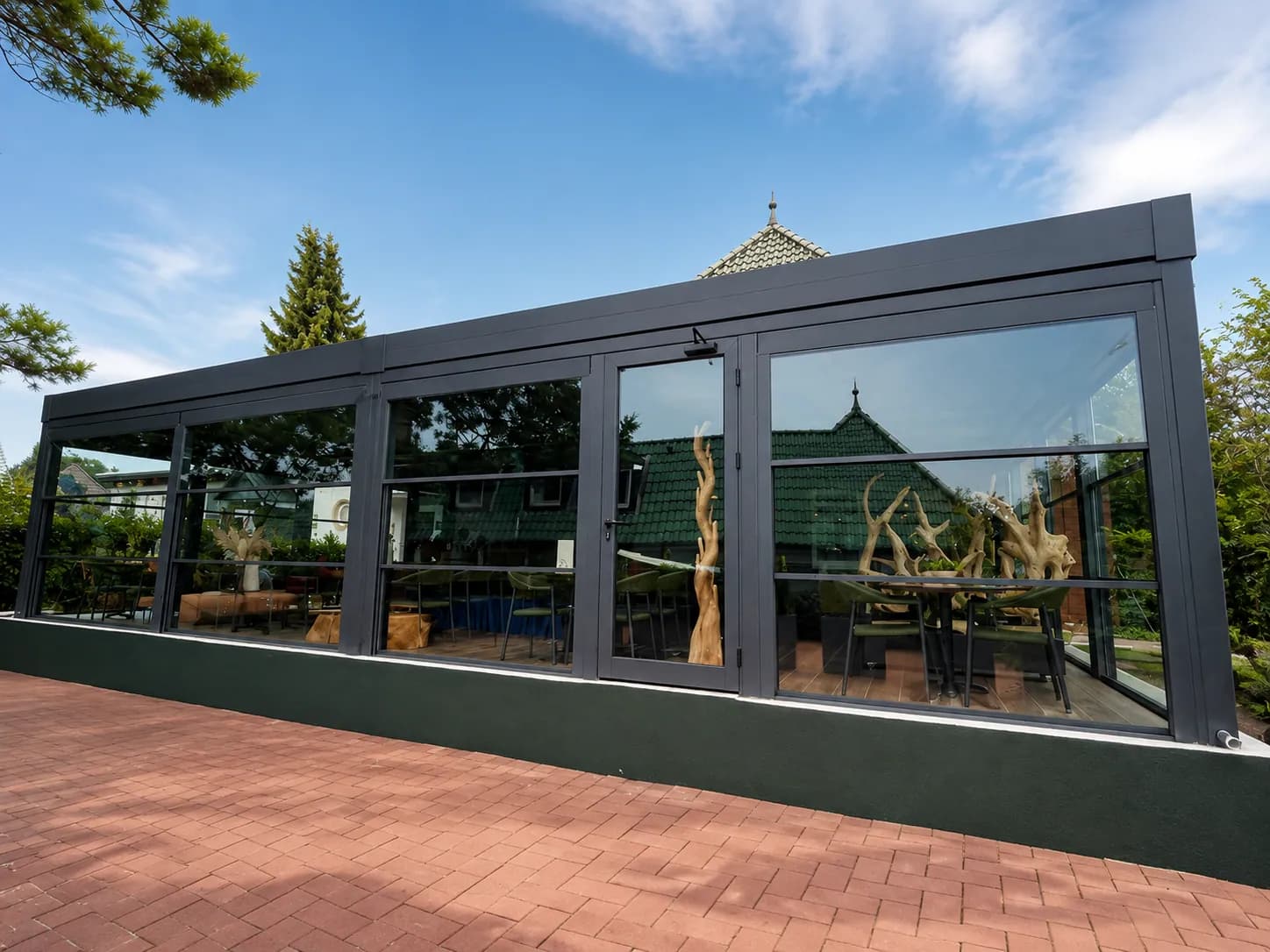 Glashaus als Café-Anbau mit rotem Pflaster