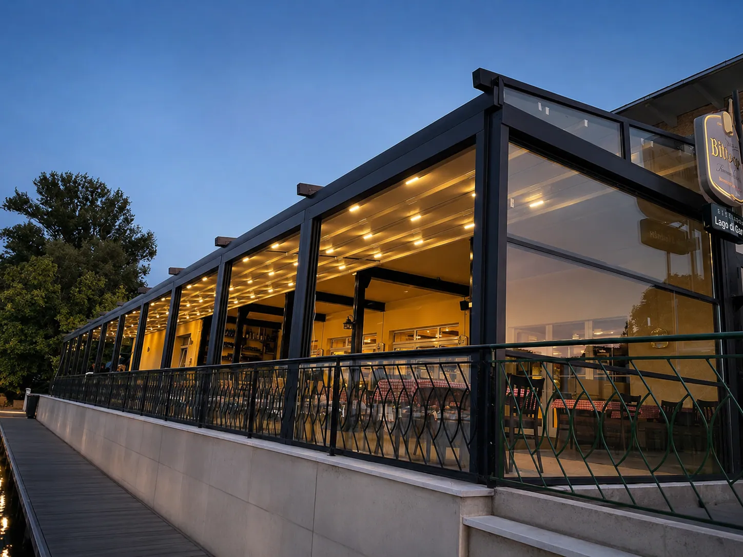 Glashaus eines Restaurants bei Nacht mit warmer Innenbeleuchtung
