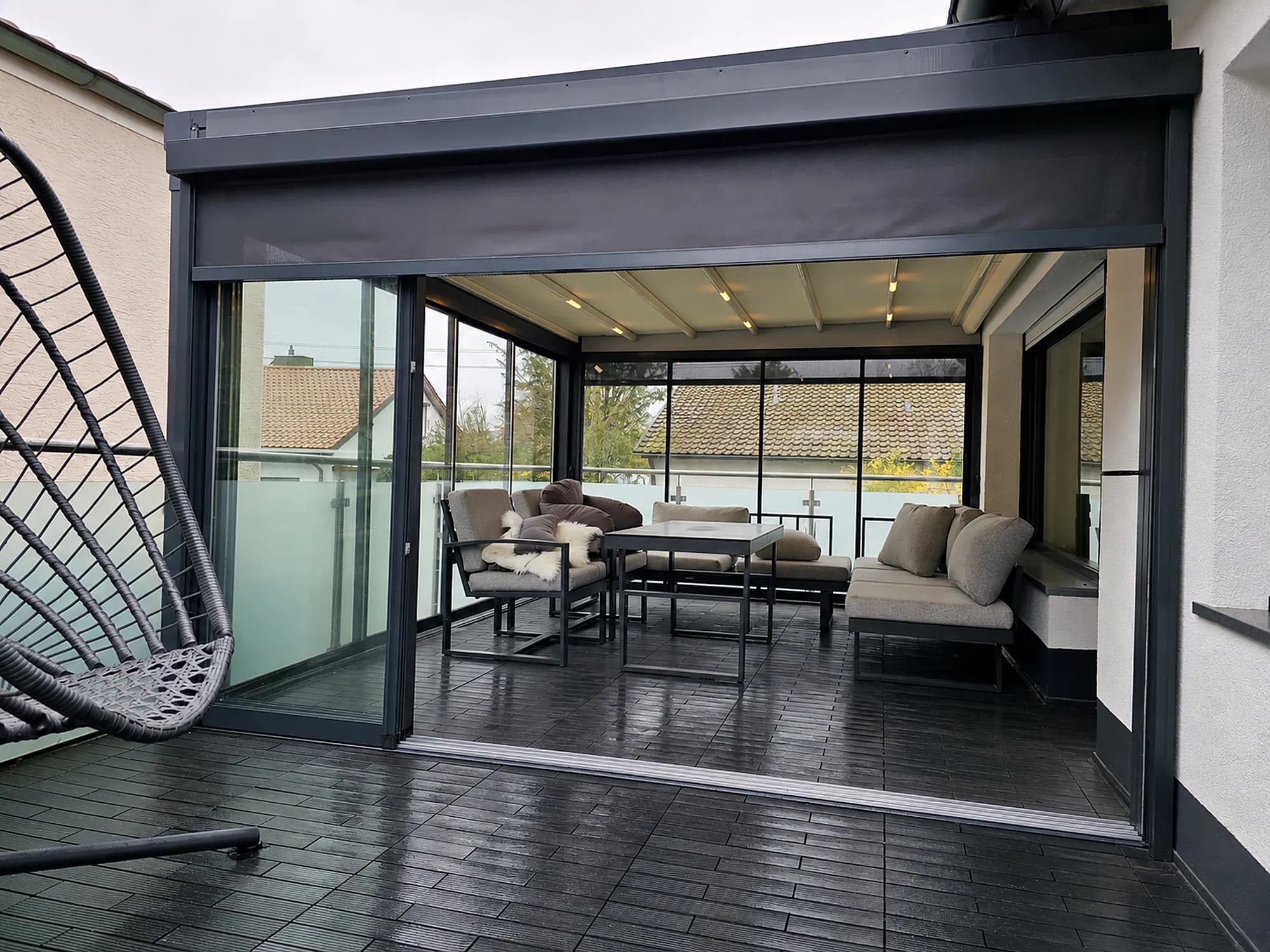 Terrassenüberdachung mit Schiebeglas, Hängesessel und Loungebereich