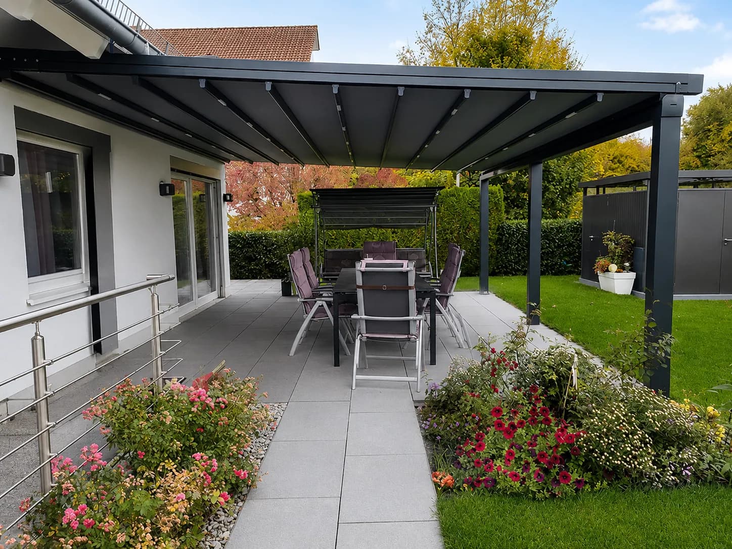Glasüberdachung über einer Terrasse mit Essplatz und Blick in den Garten