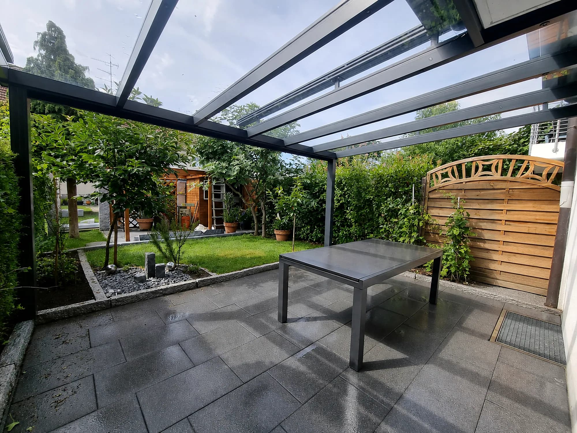 Terrassenüberdachung mit Esstisch und Blick in den Garten