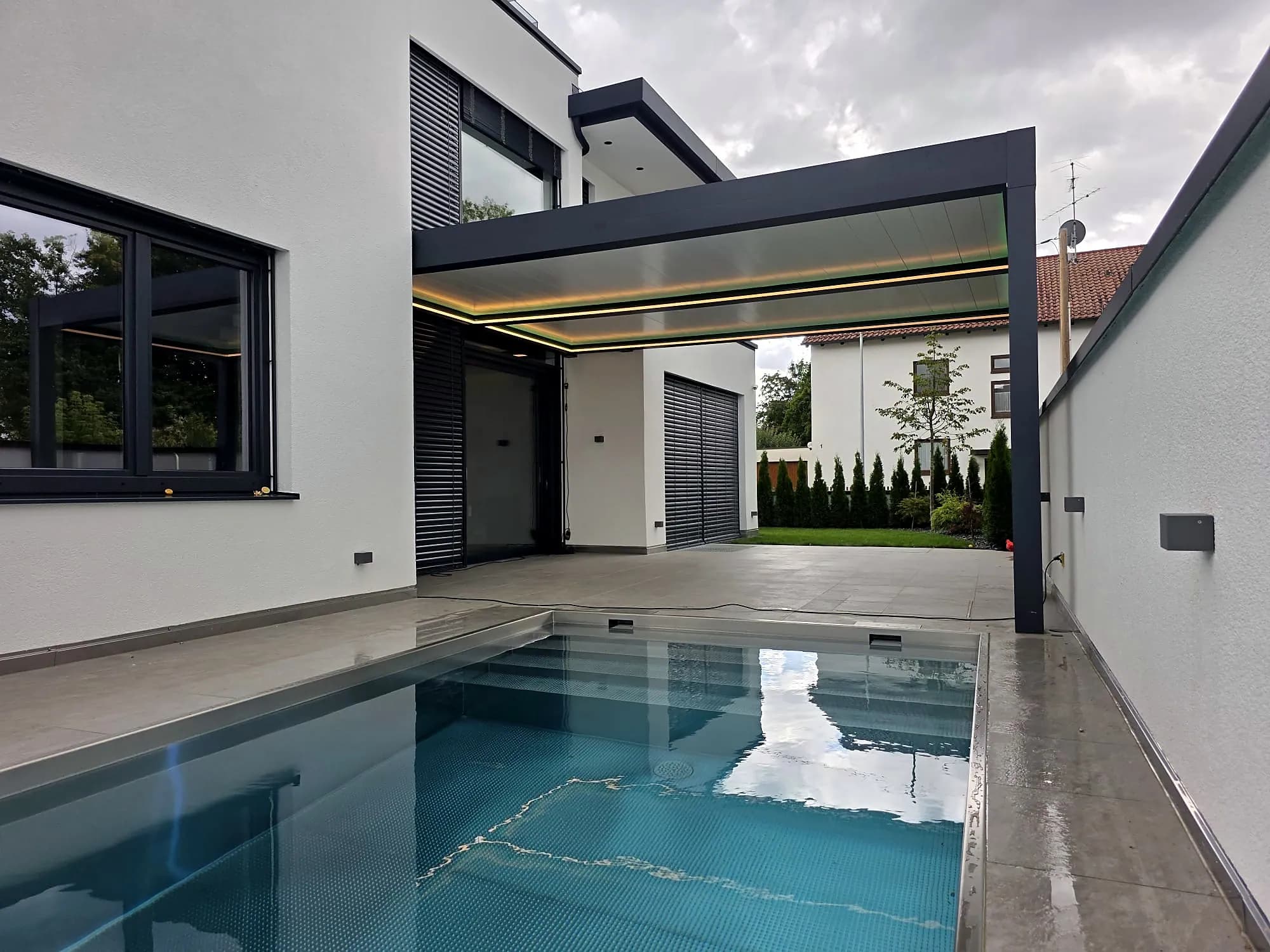 Lamellendach mit geöffneten Lamellen am Pool