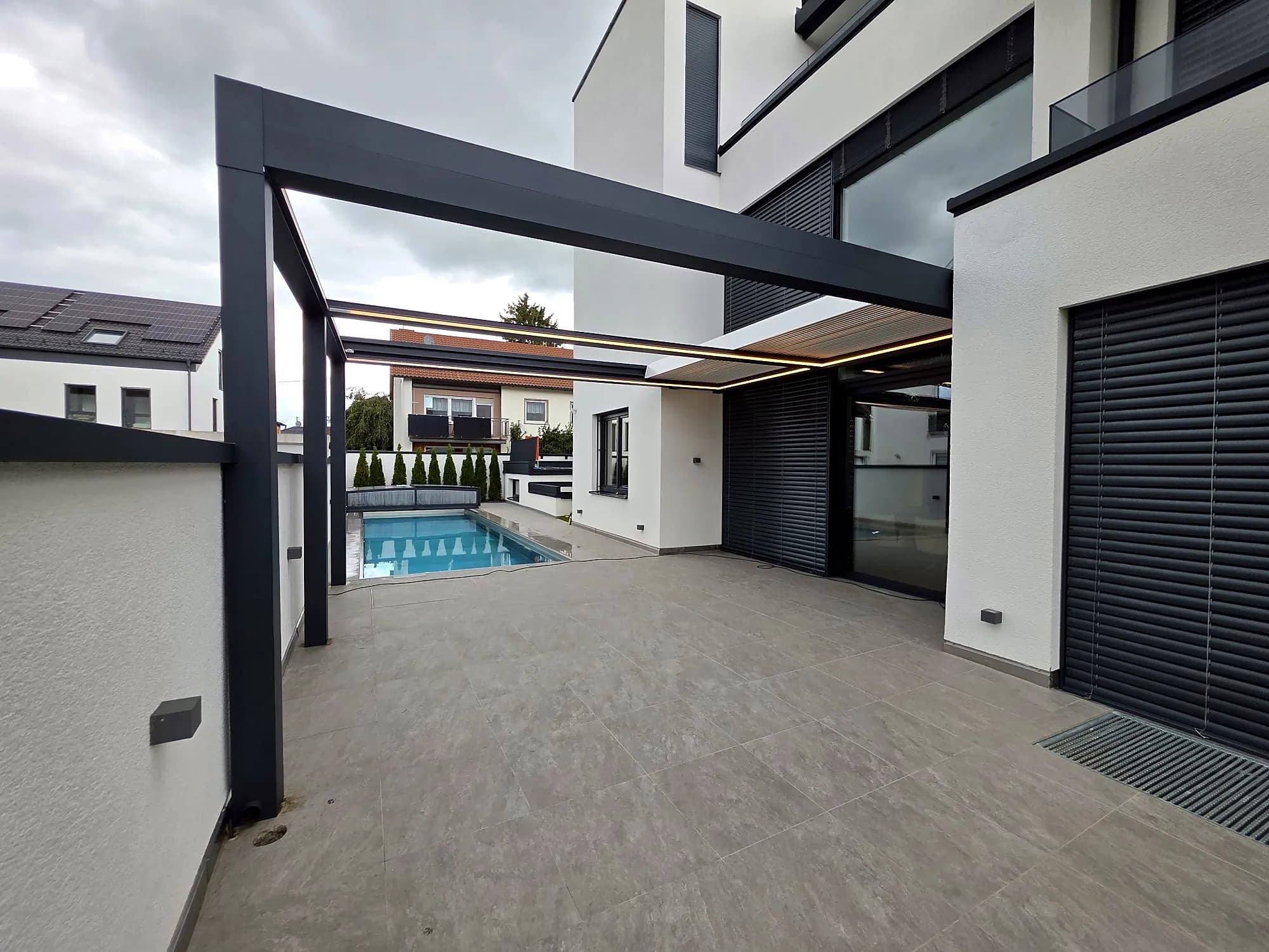 Lamellendach an einem modernen Haus mit Poolterrasse
