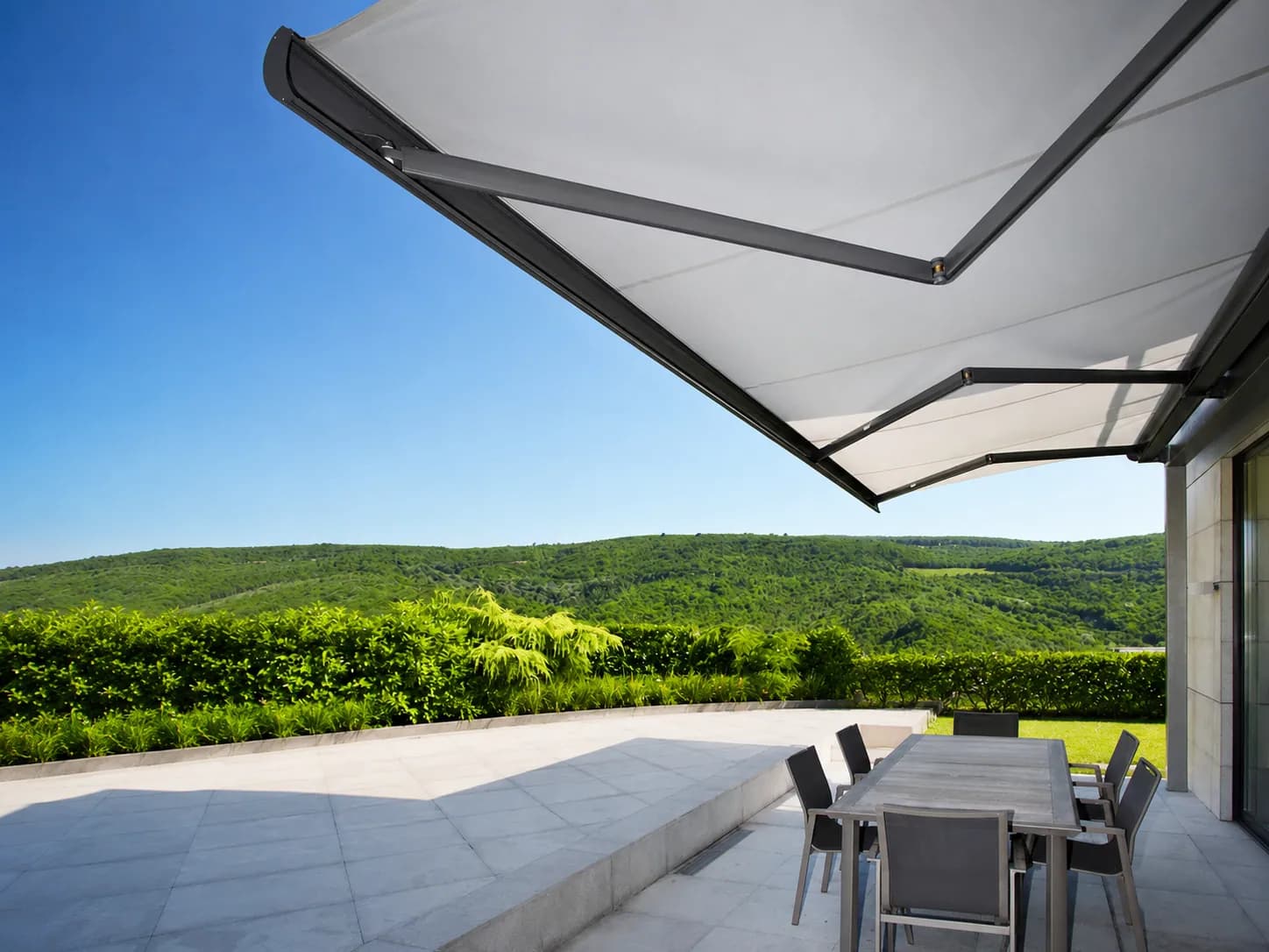 Ausgefahrene Markise über einer Terrasse mit Blick in die Hügellandschaft