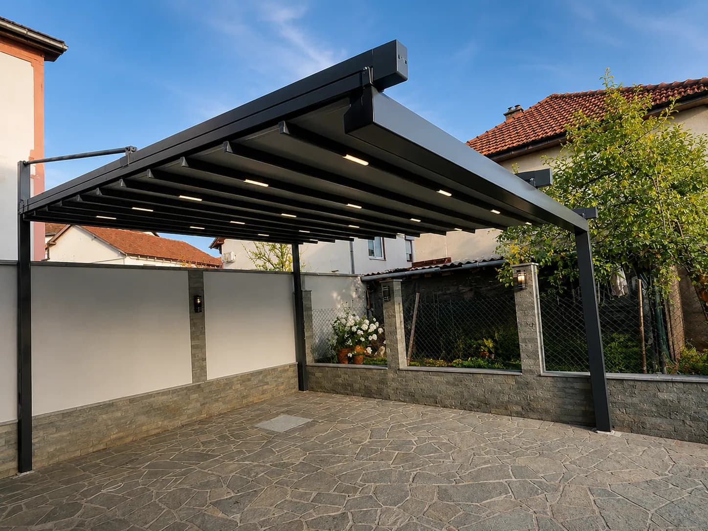 Pergola mit Faltdach und LED in einem Innenhof mit Natursteinmauer