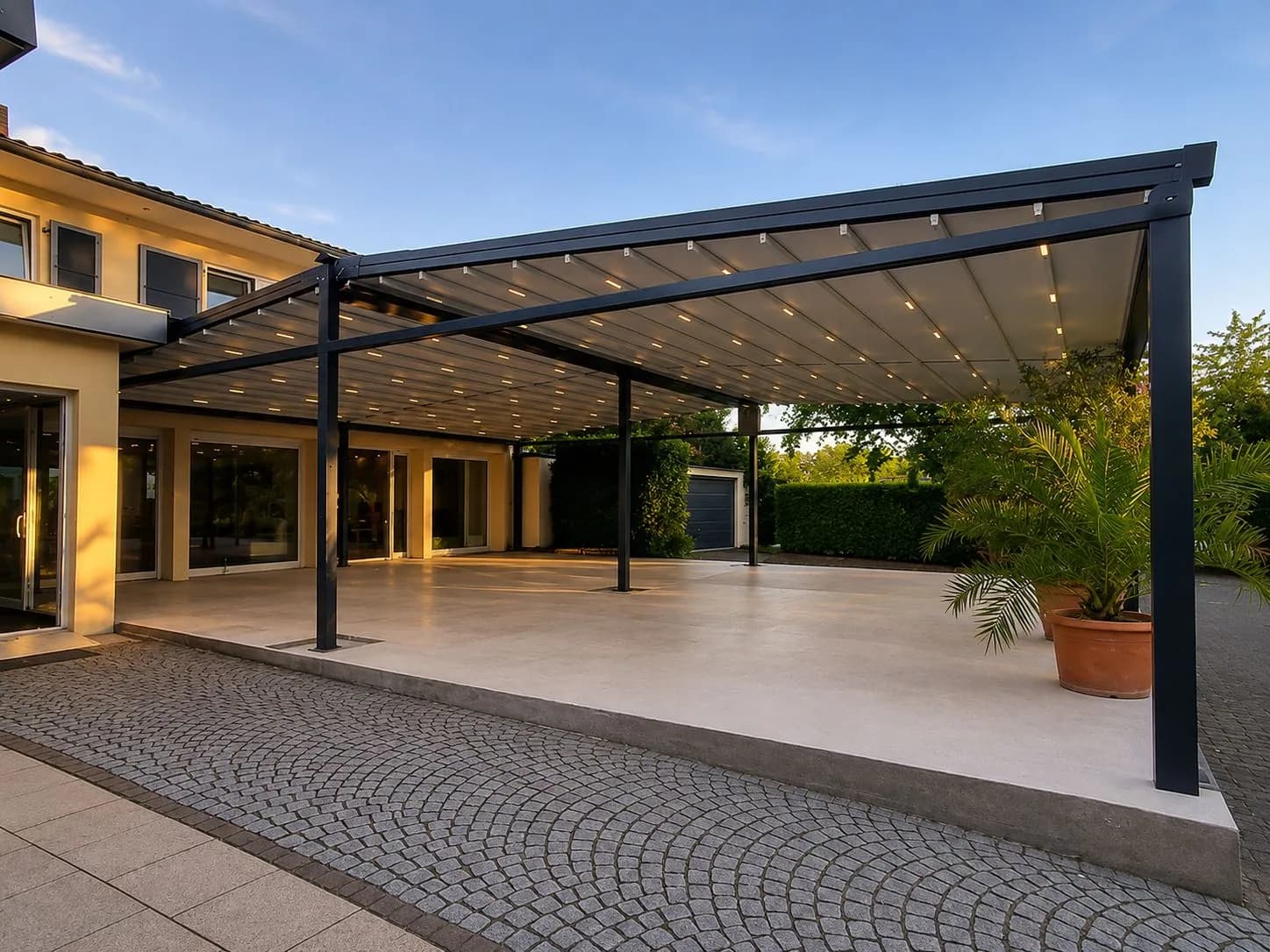 Große Pergola mit LED-Beleuchtung an einer Villa im Abendlicht