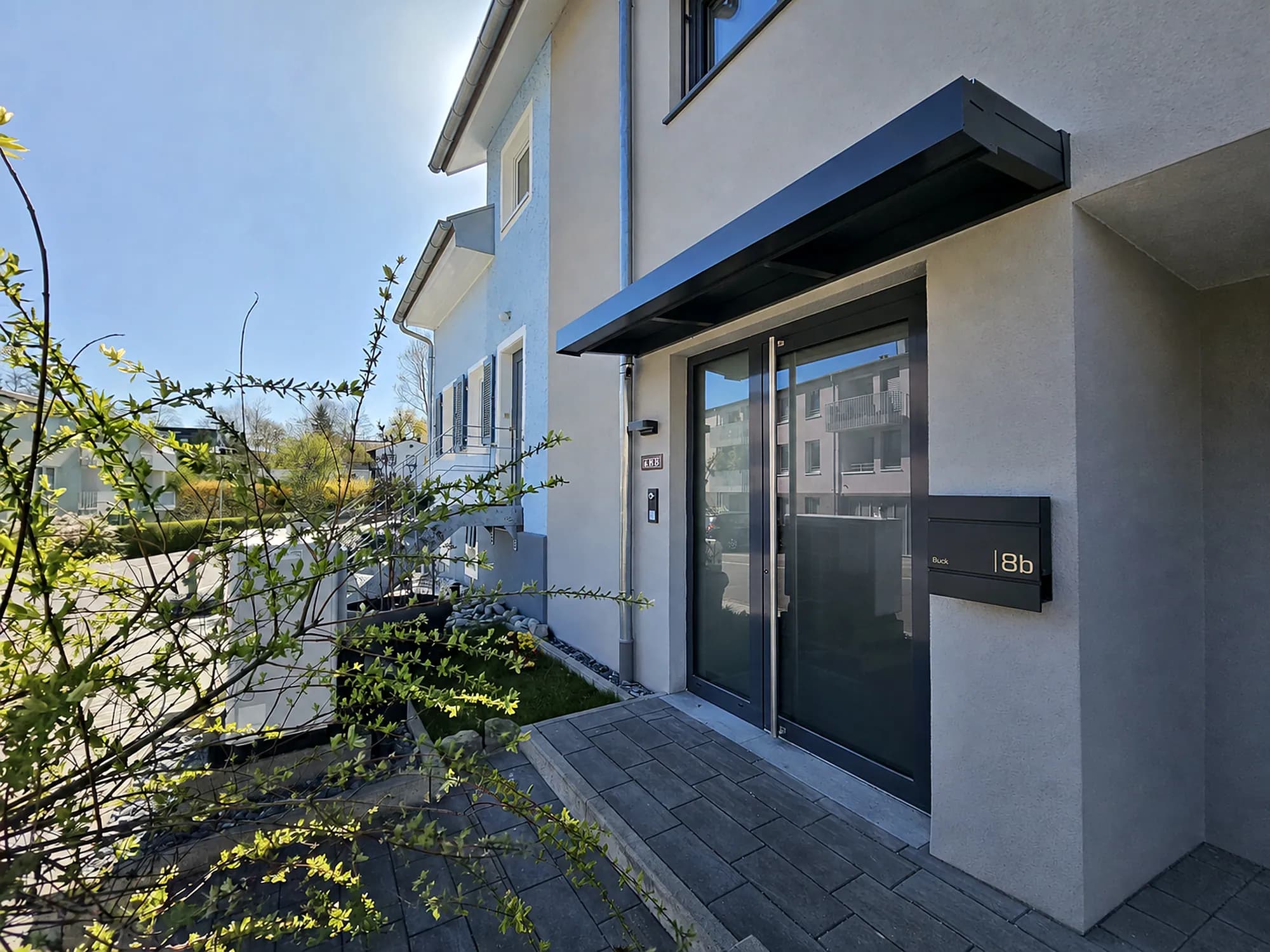 Schlankes Vordach in Anthrazit über der Haustür eines modernen Hauses