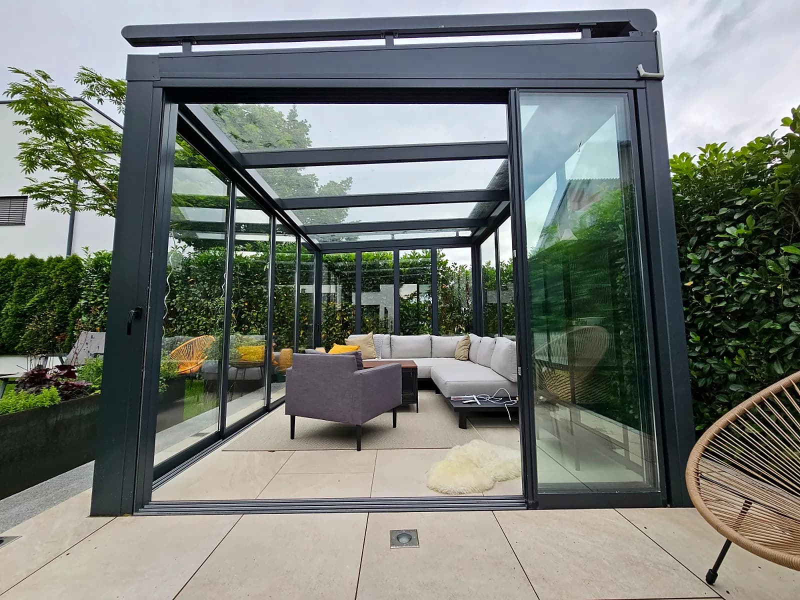Glashaus mit offener Schiebetür und Blick auf die Lounge