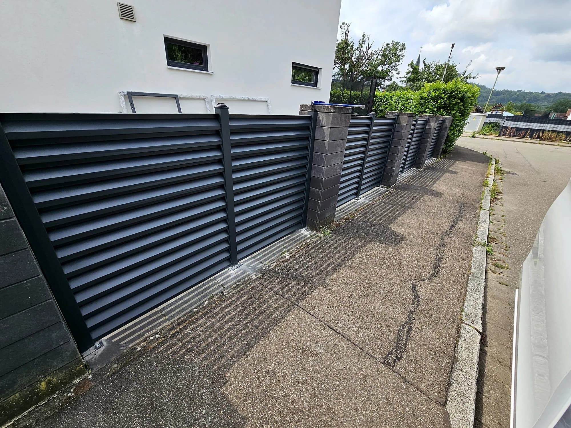 Sichtschutzzaun aus Aluminium entlang einer Straße
