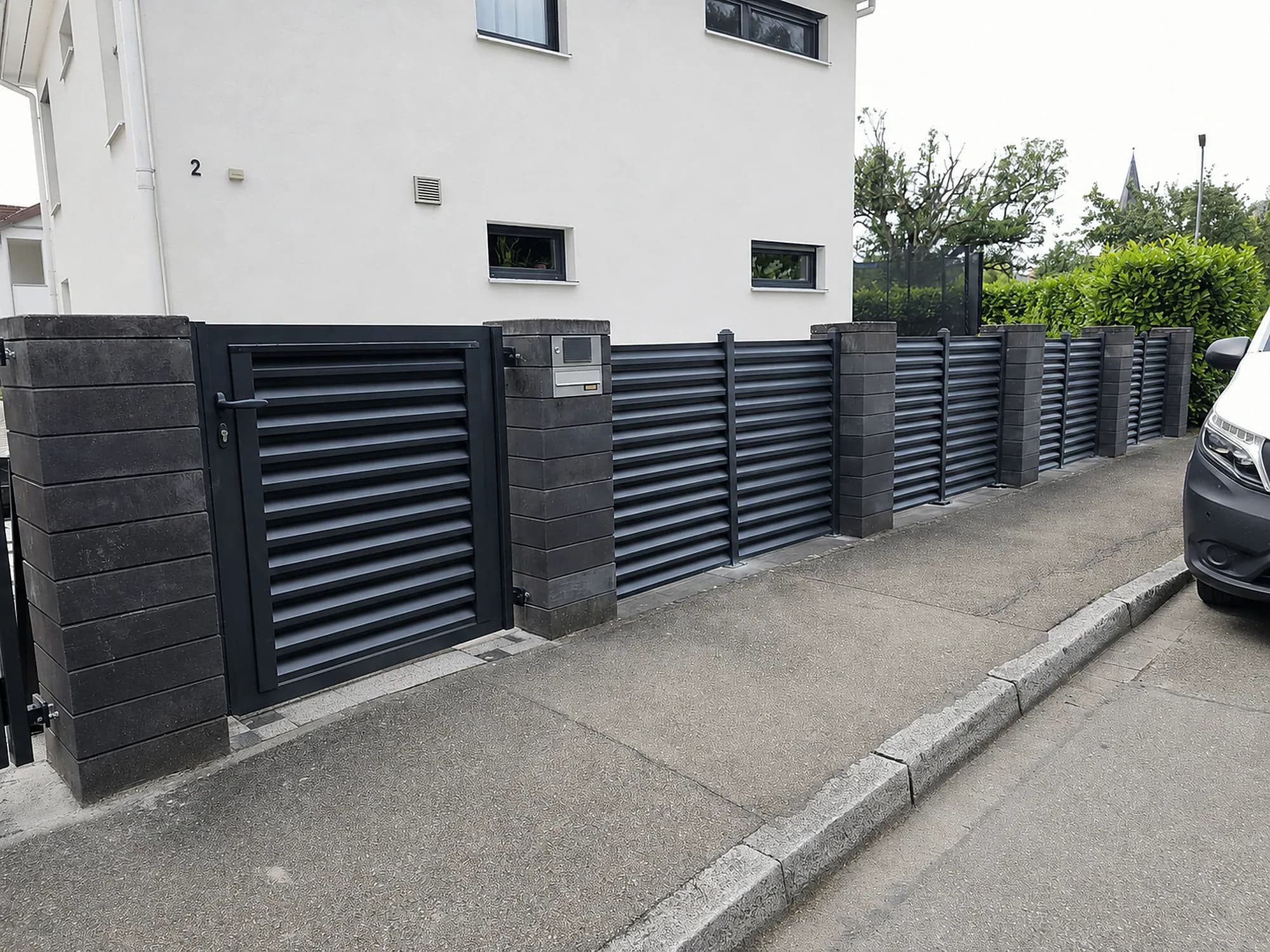 Moderner Aluminium-Lamellenzaun mit Toranlage an einem Wohnhaus